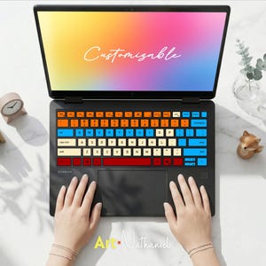 以下が含まれることがあります： オレンジ、ブルー、クリーム、レッドのキーを備えたカラフルなキーボードスキンが貼られた黒いノートパソコン。画面にはグラデーションの背景と白い筆記体でCustomizableという文字が表示されています。ノートパソコンは白い表面の上に置かれています。