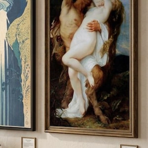 May include: A framed oil painting depicting a mythological scene with a satyr embracing a figure in a white garment, set against a dark forest background. Beside it, a second framed print shows a blue and gold waterfall landscape illustration.