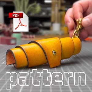 May include: A yellow leather roll-up case featuring a gold-colored metal snap fastener and a gold-colored swivel lobster clasp attached to one end. The item is presented as a PDF pattern, with the word pattern displayed in white text.