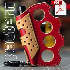 May include: A red and tan leather lighter holder featuring a knuckle duster design with four circular finger holes, stitched edges, and a black metal swivel clasp. The word pattern is printed vertically in white text on the left side of the image.