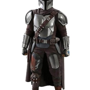 Puede incluir: Una foto de cuerpo entero de un disfraz de Mandaloriano. El disfraz presenta un casco plateado, una armadura pectoral y hombreras. El atuendo incluye una capa marr&oacute;n, pantalones y botas. Tambi&eacute;n se ve un cintur&oacute;n de herramientas y varios bolsillos.