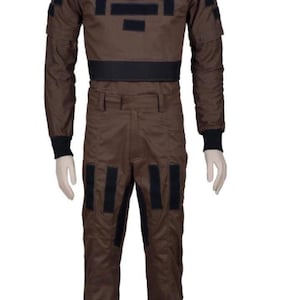 May include: Brown jumpsuit with black accents. The one-piece garment features a high collar, long sleeves, and multiple black rectangular patches. The waist is cinched with a black band, and the pants have vertical black stripes.