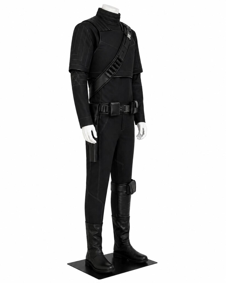 May include: A black costume displayed on a mannequin. The outfit includes a high-collared top, pants, and boots. A belt with a buckle and a shoulder strap with pouches are also visible. The costume has a sleek, modern design.
