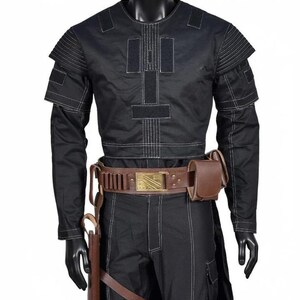 May include: Black costume with white stitching, displayed on a mannequin. The outfit includes a long-sleeved top with shoulder accents, matching pants, and a brown belt with a gold buckle. A holster and pouch are attached to the belt.