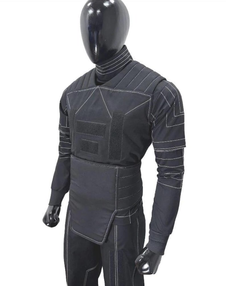 May include: Black tactical vest with white stitching, displayed on a mannequin. The vest features multiple panels, hook-and-loop closures, and long sleeves. The mannequin is black and the background is white.