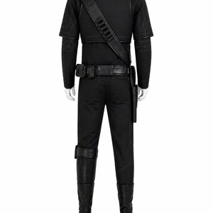 May include: A black costume displayed on a mannequin. The outfit includes a short-sleeved top, pants, boots, a belt with pouches, and a shoulder strap. The costume has quilted detailing on the shoulders and sleeves.
