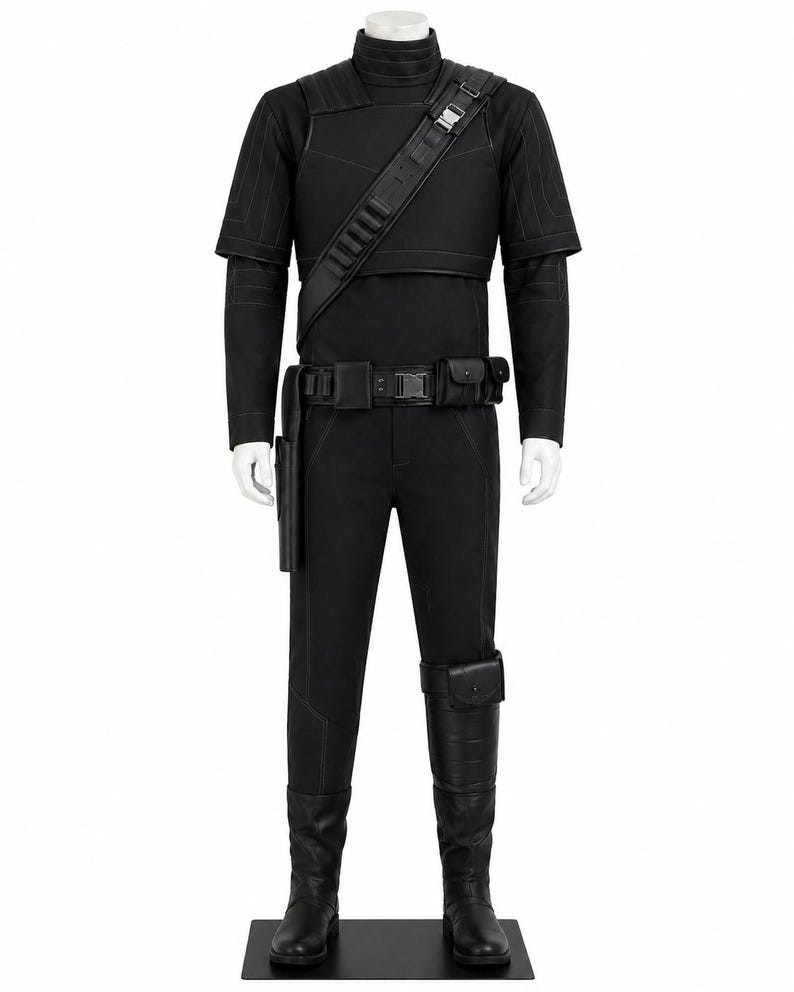 May include: A black costume displayed on a mannequin. The outfit includes a high-collared top, short-sleeved jacket, pants, belt with pouches, shoulder strap, and boots. The costume is all black and appears to be made of a durable material.