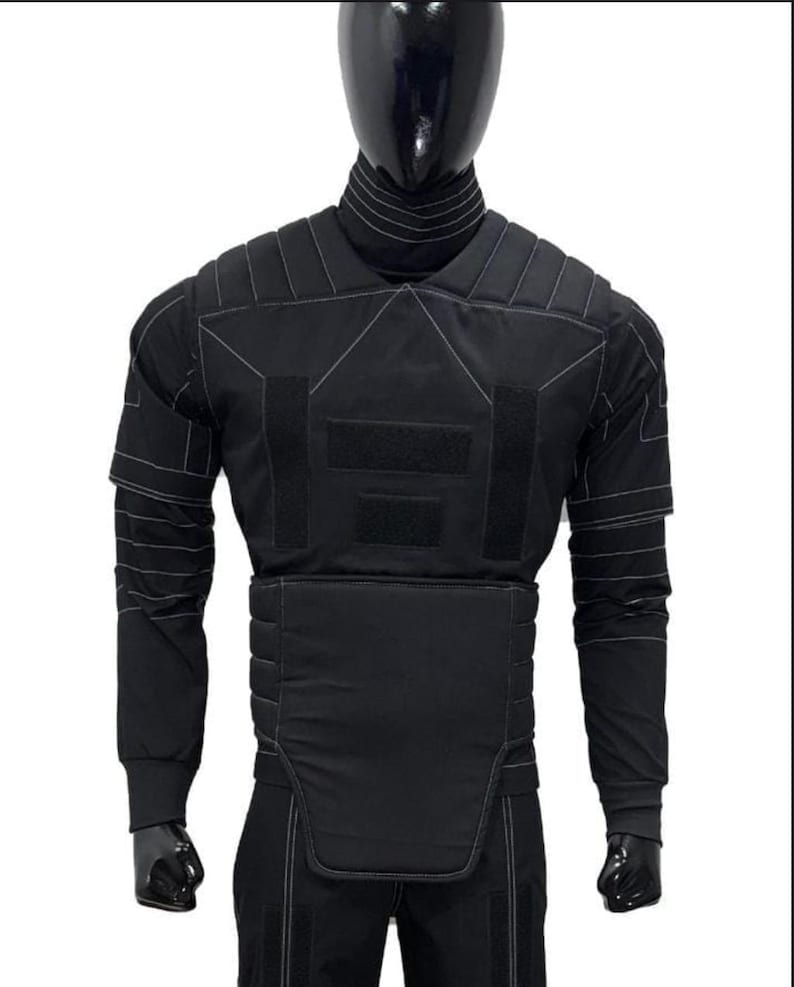 May include: Black tactical vest with white stitching details, displayed on a mannequin. The vest features multiple panels, including shoulder, chest, and waist protection. Long sleeves and a high collar are also visible.