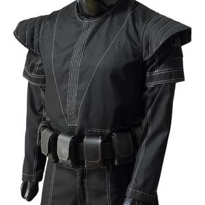 May include: Black costume with white stitching details. The outfit features structured shoulder pads, long sleeves, and a belt with multiple pouches. The design includes vertical and diagonal stitch lines, creating a unique visual texture. The costume appears to be made of a durable fabric.
