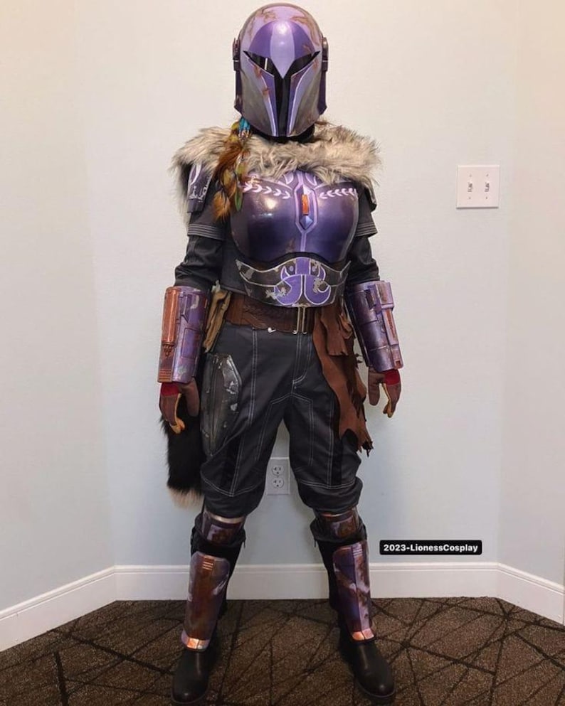 May include: A full-body shot of a detailed cosplay costume. The costume features a purple helmet, chest armor, and arm guards with silver accents. The outfit includes a fur collar, dark pants, and boots. The overall design suggests a futuristic or sci-fi theme.