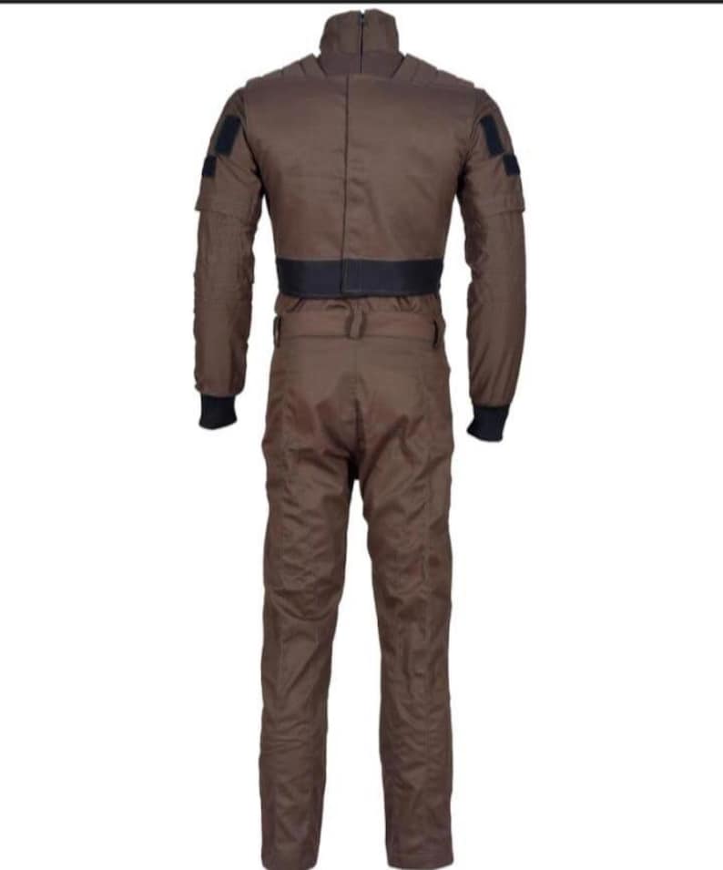 May include: A brown jumpsuit with a high collar and black accents. The one-piece garment features a black belt at the waist, black cuffs, and patches on the upper arms. The back view shows the full length of the suit.