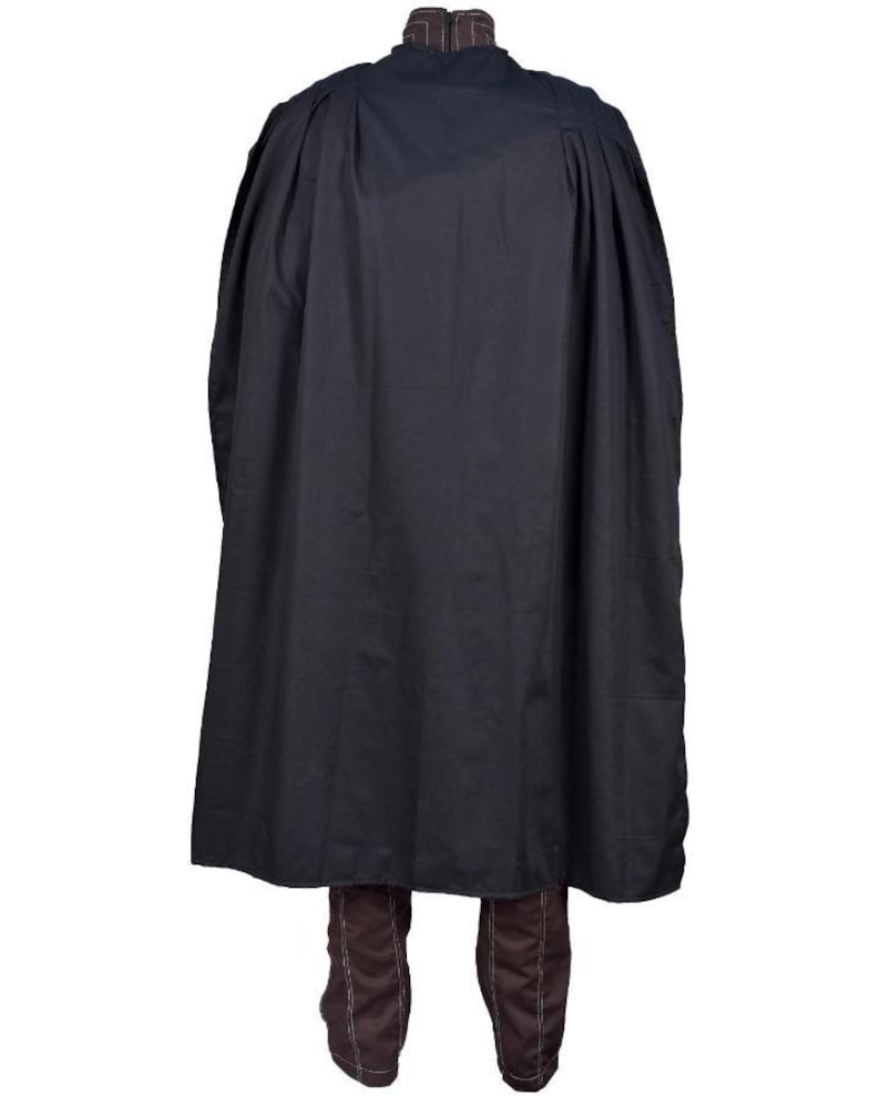 Puede incluir: Una capa negra con cuello alto y dise&ntilde;o fluido. La capa est&aacute; hecha de una tela oscura y se combina con botas marrones. La prenda parece ser un disfraz o ropa hist&oacute;rica.