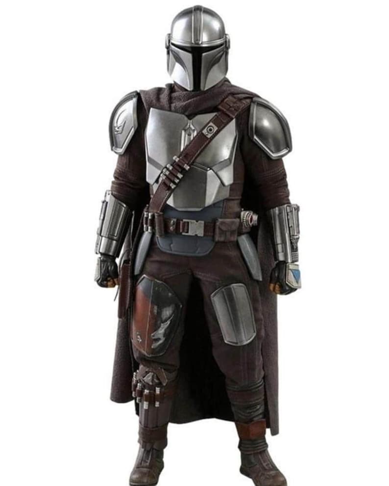 Puede incluir: Una foto de cuerpo entero de un disfraz de Mandaloriano. El disfraz presenta un casco plateado, una armadura pectoral y hombreras. El atuendo incluye una capa marr&oacute;n, pantalones y botas. Tambi&eacute;n se ve un cintur&oacute;n de herramientas y varios bolsillos.