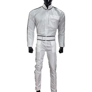 May include: A white racing suit with black trim, displayed on a mannequin. The suit features a zip-up jacket with a stand-up collar, a chest pocket, and matching pants. The suit has black stripes down the sleeves and legs.