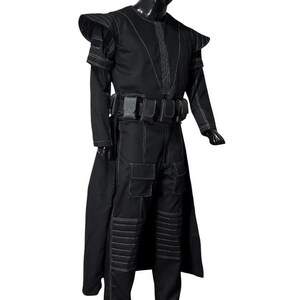 May include: A black costume with white stitching, featuring a long coat, shoulder pads, and a utility belt. The pants have pockets and reinforced knee sections. The costume is designed with a futuristic or fantasy theme.