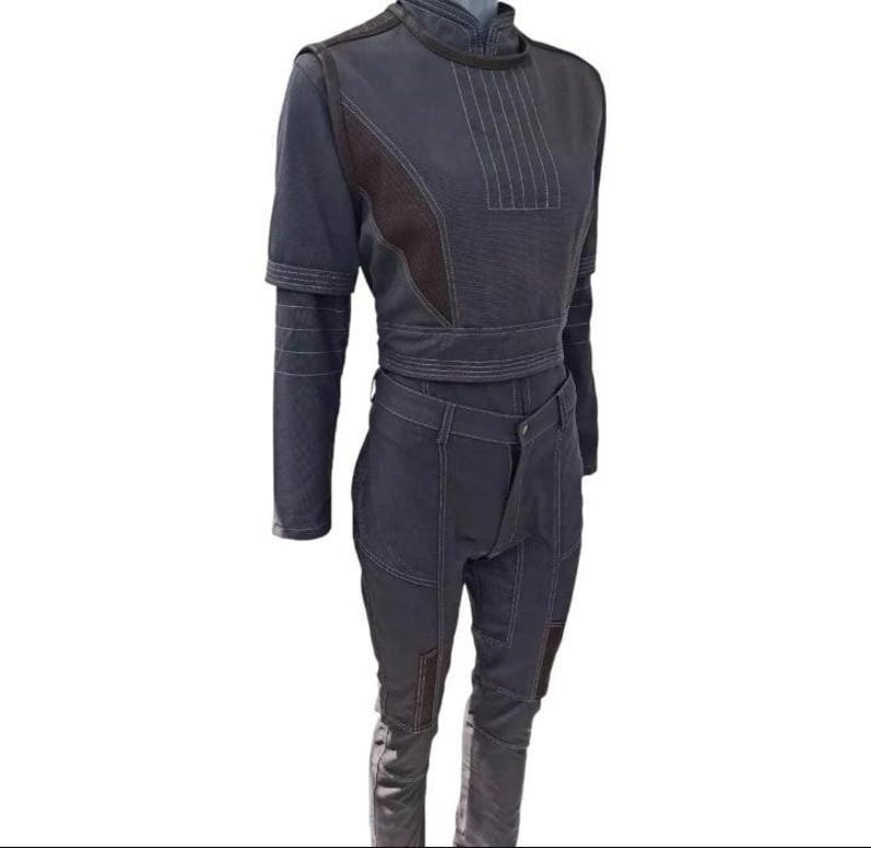 May include: A dark gray two-piece outfit with a high collar, long sleeves, and a fitted waist. The top features vertical stitching and a brown panel on the chest. The pants have a unique front design and knee patches. The outfit is made of a durable material.