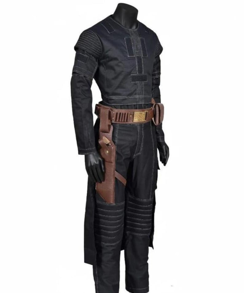 May include: Black costume with white stitching, featuring a long-sleeved top, pants, and a brown leather belt with a holster. The outfit is displayed on a mannequin, showcasing a futuristic or sci-fi aesthetic. The costume includes padded details on the shoulders and knees.