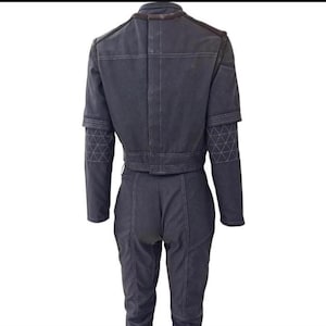 Puede incluir: Mono gris oscuro con chaqueta corta y pantal&oacute;n a juego. La chaqueta tiene cuello y detalles en los hombros marrones, con mangas estampadas geom&eacute;tricas. El pantal&oacute;n es de cintura alta y ajustado. El mono est&aacute; hecho de una tela resistente.