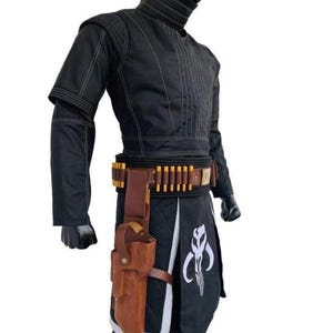 May include: Black costume with white stitching, featuring a high collar and a belt with gold-colored details. A brown holster is attached to the belt, and a white emblem is visible on the lower garment. The costume is designed for cosplay or themed events.