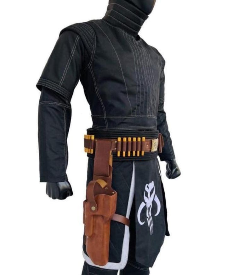 May include: Black costume with white stitching, featuring a high collar and a belt with gold-colored details. A brown holster is attached to the belt, and a white emblem is visible on the lower garment. The costume is designed for cosplay or themed events.