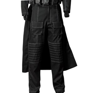 May include: Black tactical pants with white stitching details. The pants feature multiple pockets and reinforced knee panels. A black coat is visible in the background. The pants are part of a costume or uniform.
