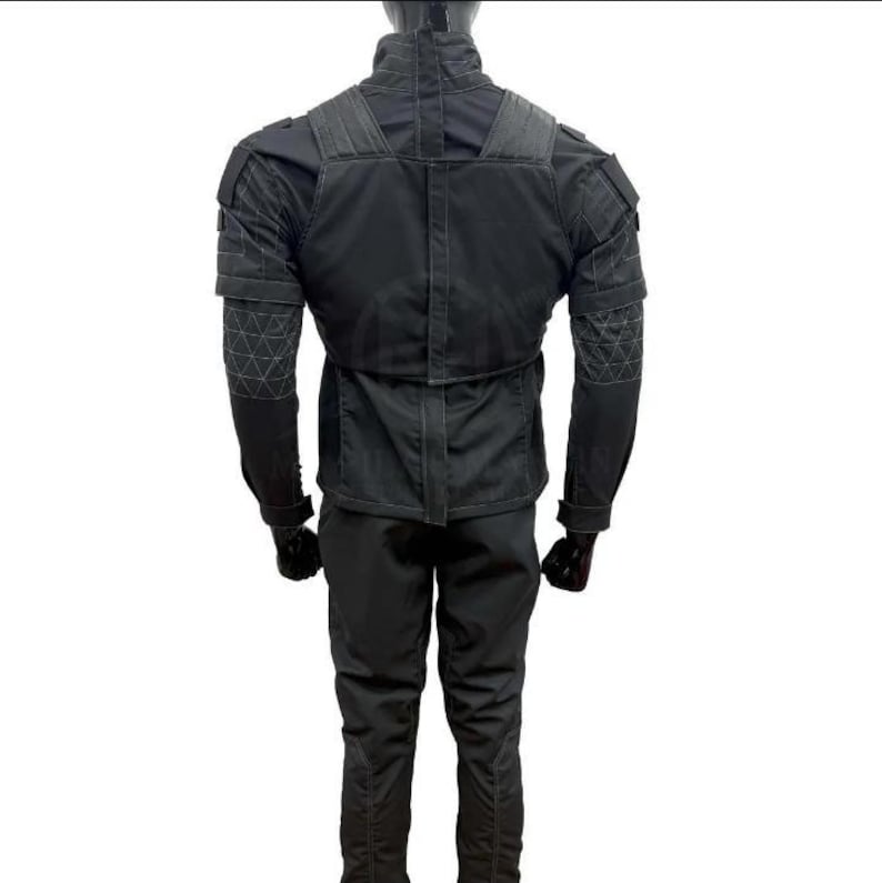 May include: A black tactical jacket and pants set. The jacket features reinforced shoulder and elbow patches, with a high collar and multiple pockets. The pants have a slim fit. The outfit is designed for durability and functionality.
