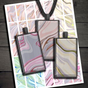 May include: Three rectangular glass pendants with a marbled design in shades of pink, gray, and beige. The pendants are hanging from a black chain.