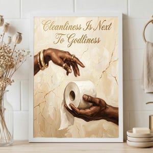 May include: A framed wall art print featuring an oil painting style depiction of two hands reaching toward each other, with one hand offering a roll of toilet paper. The text Cleanliness Is Next To Godliness is printed in gold script at the top.
