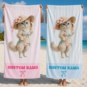 Puede incluir: Dos toallas de playa, una rosa y otra azul, cada una con un gato de dibujos animados con sombrero de paja y bikini. Las toallas tienen rayas verticales y el texto "CUSTOM NAME" en la parte inferior.