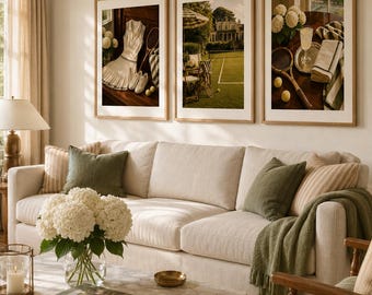May include: Three framed wall art prints featuring tennis-themed photography, including a white tennis dress, a grass court, and vintage rackets with a drink, displayed in light wood frames above a beige sofa with green and striped throw pillows.