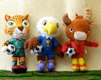 2026 WM Maskottchen Plüsch Ahorn Zayu Clutch Stofftier, 30 cm offizielle Fußballpuppe, USA Kanada Mexiko Fußballfan Geschenk