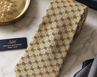 Corbata Brooks Brothers 346 de seda pura, color dorado, beige y negro, con estampado geométrico. Hecha en EE. UU.