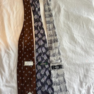 May include: A trio of ceramic mugs with a speckled, matte finish in cream, light grey, and dark grey. Each mug features a simple, minimalist design, ideal for tea or coffee.