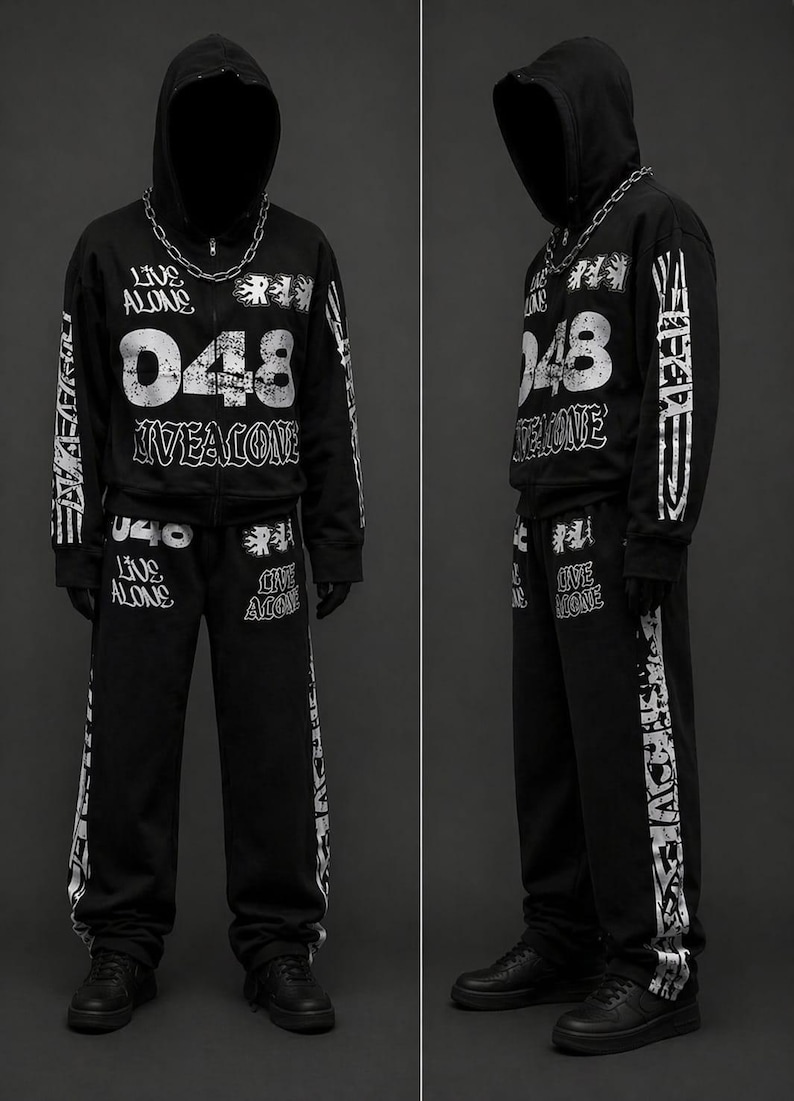 May include: Black hooded sweatshirt and matching sweatpants set with white graphic text and numbers. The text includes "LIVE ALONE" and "048". A silver chain necklace is worn with the hoodie. The outfit is completed with black sneakers.