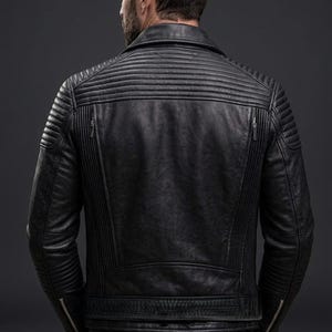 May include: A black leather jacket featuring horizontal quilted padding on the shoulders and upper back, vertical ribbed panels along the sides, a fold-down collar, and silver-toned metal zips on the cuffs and two vertical back pockets.