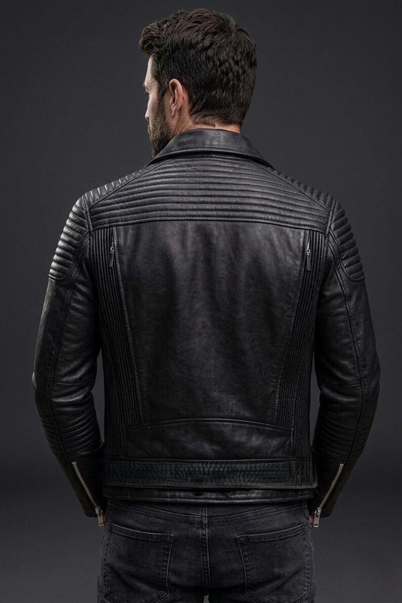 May include: A black leather jacket featuring horizontal quilted padding on the shoulders and upper back, vertical ribbed panels along the sides, a fold-down collar, and silver-toned metal zips on the cuffs and two vertical back pockets.