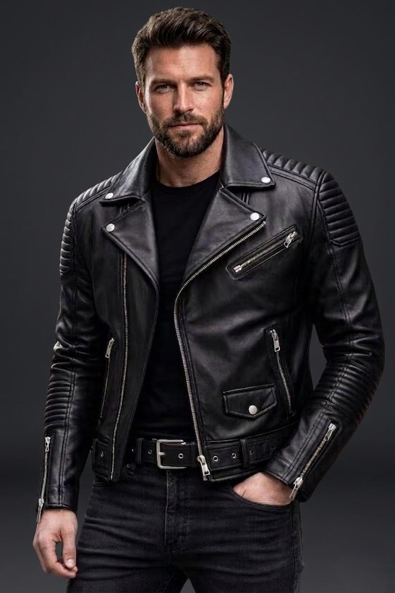 May include: A black leather motorcycle jacket featuring a notched lapel, silver-tone metal zips, and snap-button closures. The jacket includes quilted shoulder and sleeve detailing, a waist belt with a metal buckle, and a black t-shirt underneath.