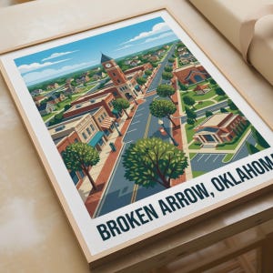 May include: A framed art print featuring a stylized illustration of a town street in Broken Arrow, Oklahoma. The image depicts a clock tower, brick buildings, green trees, and a road under a blue sky with clouds. The text reads BROKEN ARROW, OKLAHOMA.