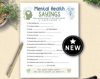 May include: A white Mental Health Sayings worksheet with fill-in-the-blank prompts. The worksheet includes the text "It's okay not to be okay" and a "NEW" sticker. A gold pen and eyeglasses are in the image.