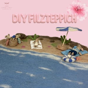 Op de afbeelding: Een naaldgevilte strandscène met vijf kleine muisfiguren op een beige zandmat en een blauw oceaangedeelte. De scène bevat een blauw-wit gestreepte parasol, een witte handdoek, een blauwe handdoek, een reddingsboei en een zandkasteel.
