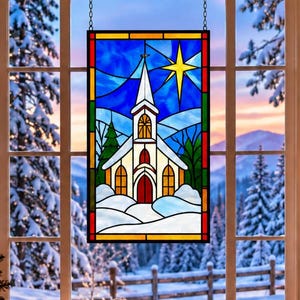 May include: A rectangular stained glass window hanging featuring a white church with a steeple, a bright yellow star, and a snowy landscape in shades of blue, green, and white. The design is enclosed in a dark frame with a chain for hanging.