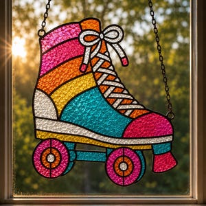 May include: A stained glass suncatcher shaped like a roller skate with a textured surface. The skate features vibrant panels of pink, orange, yellow, and teal glass, outlined in black metal. It hangs from a black metal chain against a window.