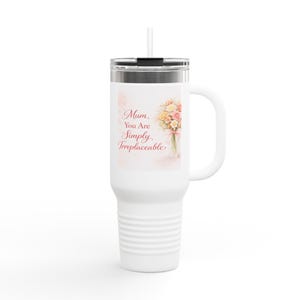 Könnte beinhalten: Weißer Reisebecher mit Henkel und silbernem Deckel. Der Becher zeigt ein Blumenstrauß-Design und den Text "Mum, You Are Simply, Irreplaceable". Inklusive Strohhalm.