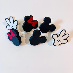 Könnte beinhalten: Ein Set aus drei Keramikbechern mit gesprenkelter, matter Oberfläche. Die Becher sind in Creme-, Hellgrau- und Dunkelgrautönen gehalten. Jeder Becher hat ein schlichtes, minimalistisches Design und einen abgerundeten Henkel. Für Kaffee oder Tee.