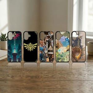 May include: Five phone cases with different designs. The cases have black borders and feature various graphics, including a golden emblem, a collage of images, and illustrations with a fantasy theme. The cases are displayed on a wooden surface.