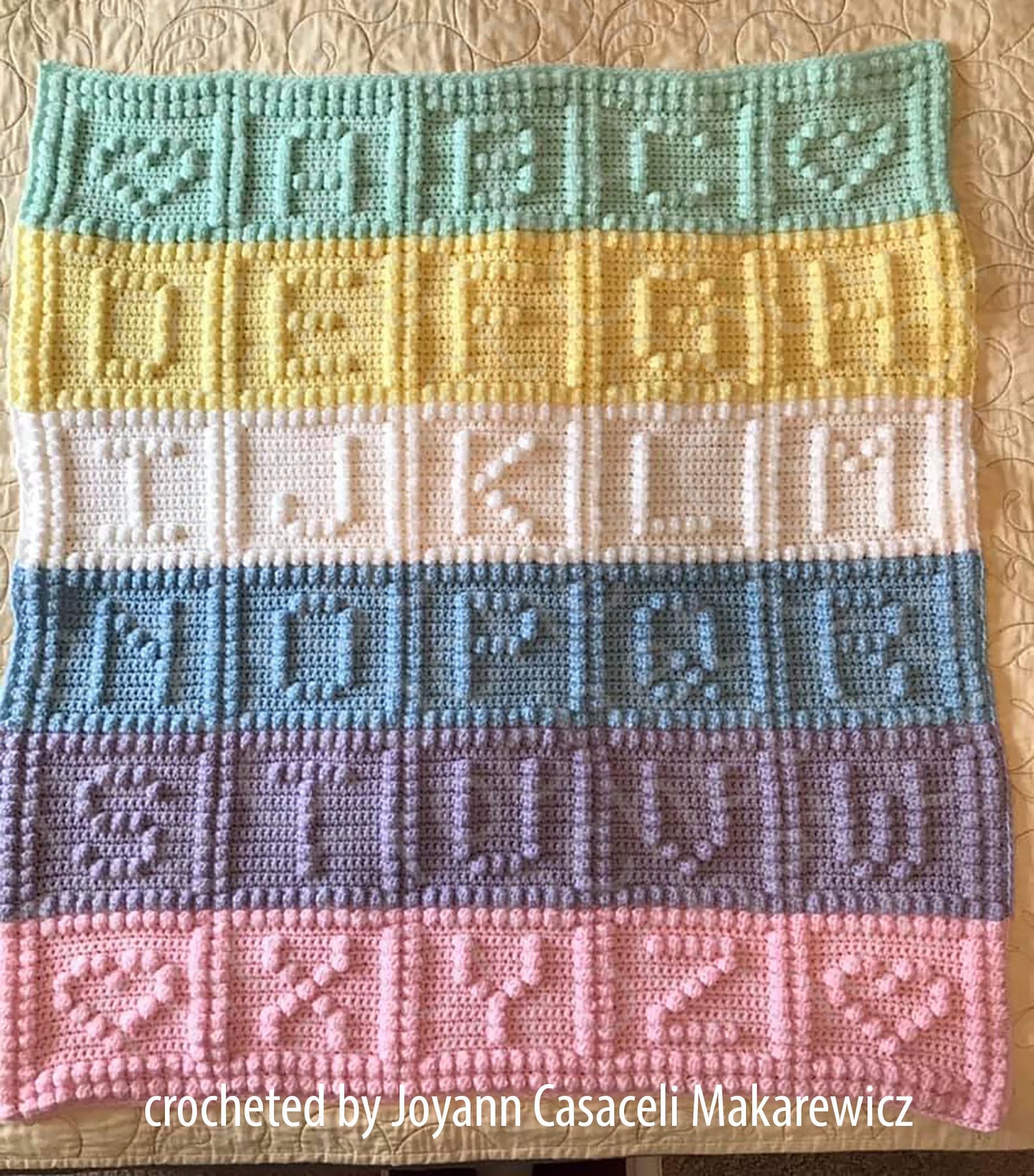 Alphabet baby afghan with bobble stitch letters in rows of yellow, green, blue, purple, and pink, crocheted by Joyann Casaceli Makarewicz