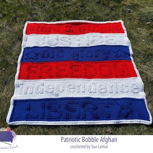 May include: A crocheted blanket in red, white, and blue with the words "Stars & Stripes", "Justice", "God Bless", "Freedom", "Independence", and "Liberty" in raised lettering.
