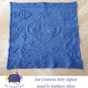 May include: A blue crocheted baby blanket featuring a sea creature design. The blanket incorporates a variety of sea creatures, including fish, starfish, and seahorses. The blanket is crafted from a soft, textured yarn and is ideal for snuggling.