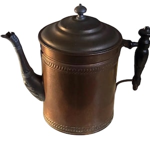 Cafetera antigua de cobre con detalles de peltre y mango de madera.