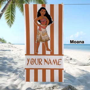 May include: A rectangular beach towel featuring vertical orange and white stripes. The center displays a cartoon illustration of Moana with long dark hair, wearing a patterned top and skirt. Below the character, the text YOUR NAME is printed.